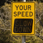 digital traffic sign says slow down